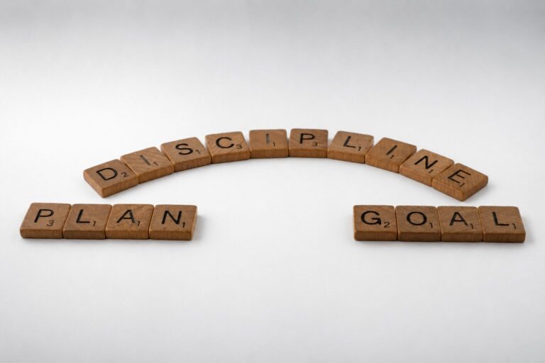 Fa Scrabble-kockákból ívesen kirakott PLAN, DISCIPLINE és GOAL szavak, a tervezés és az időgazdálkodás témáját szimbolizálva