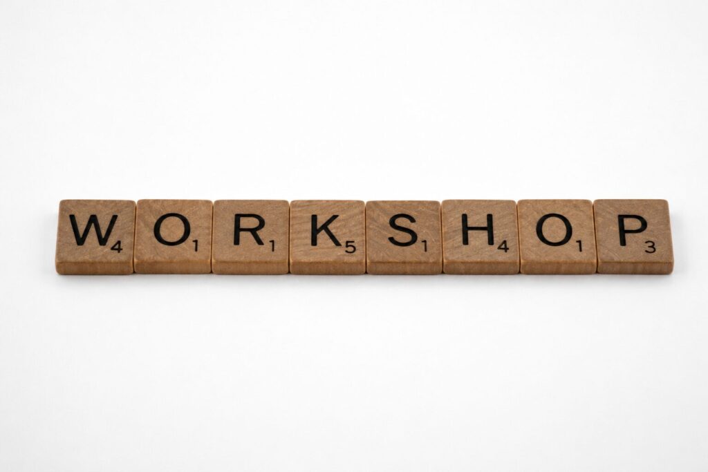 Fa táblára festett WORKSHOPS felirat, a workshopok vezetésének témáját szimbolizálva